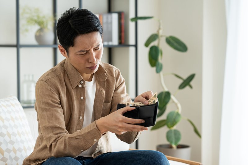 財布を見て困惑する男性
